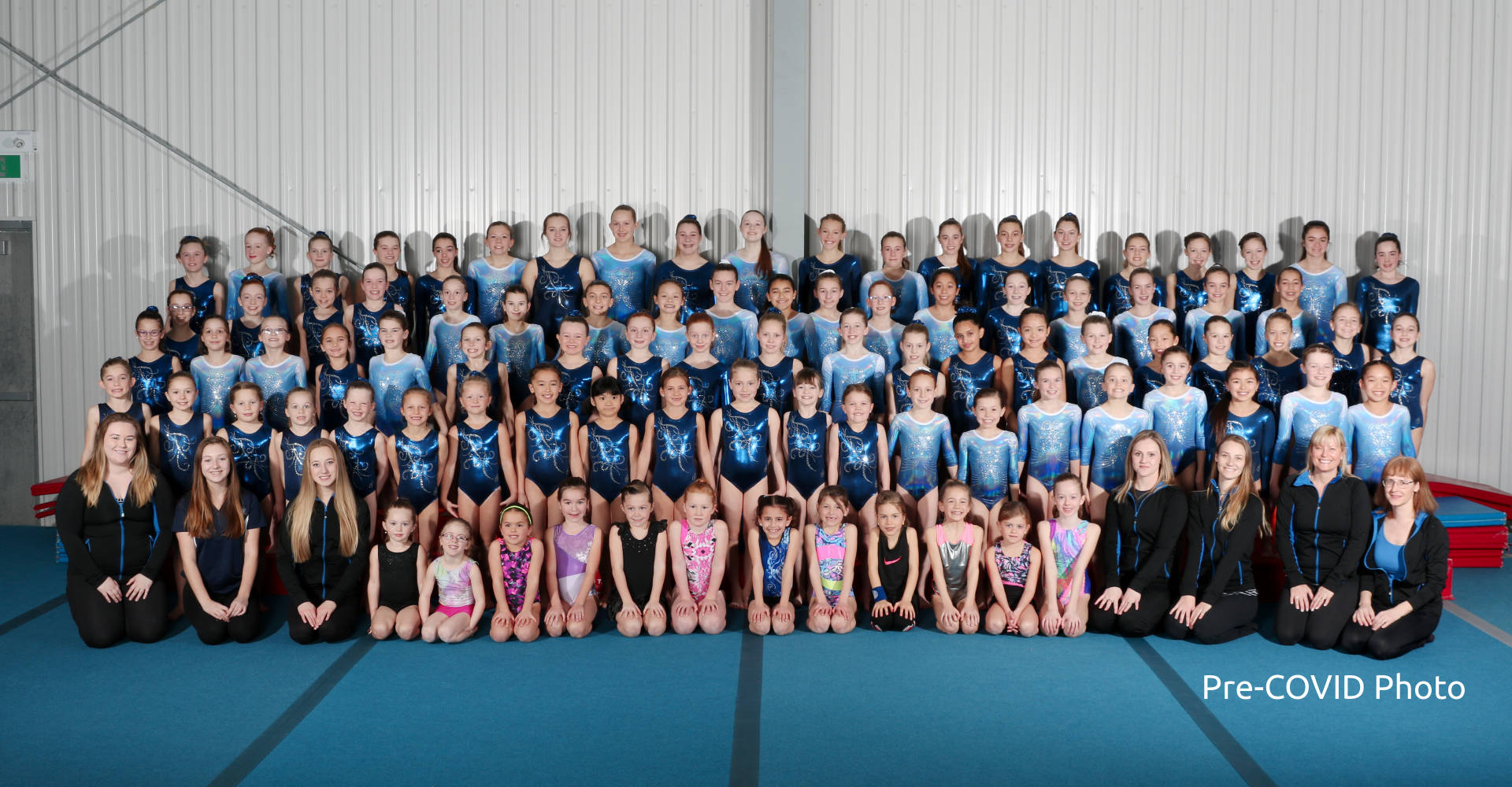 A group photo of competitive and pre-competitive gymnastics teams, with their coaches at Gymworld in London